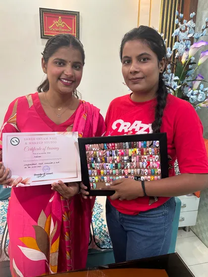 Celebrating the completion of the nail art course with a happy student. She's holding her certificate and her fantastic work.