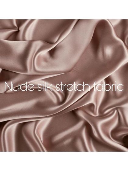 A swatch of nude silk stretch fabric, capturing its soft, fluid texture. This material is ideal for creating garments that move with the body, offering both comfort and sensuous elegance.