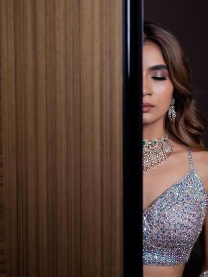 A creative portrait that highlights the intricate details of her sparkling lehenga and the flawless finish of her reception makeup.