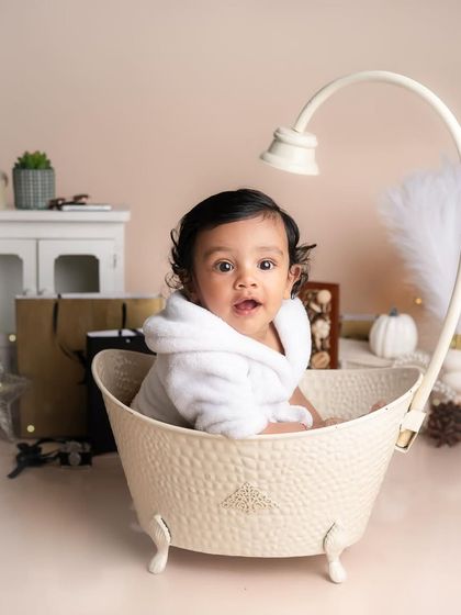 A spa day for our adorable boy. This cute setup with a mini bathtub and a fluffy bathrobe is a creative and fun idea for a milestone session.