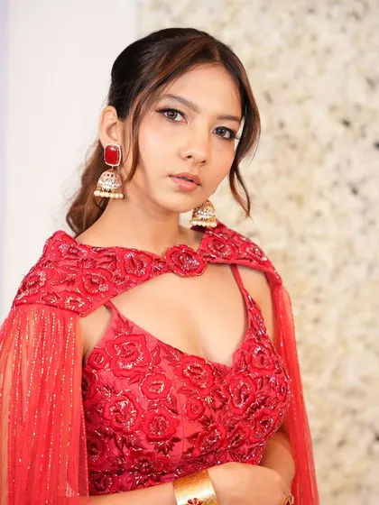 A front-facing view of this stunning red engagement outfit, where the makeup is kept soft and glowing to let the outfit shine.