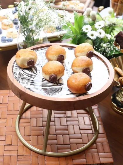 The Moon Ray stand with a monochrome leaf print, serving delicious doughnuts. Its elevated design and stylish pattern make it a versatile addition to your hosting collection.