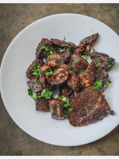 For the true carnivore, I offer Bannur Lamb Organs Pepper Fry. This dish features a mix of liver, heart, kidneys, and spleen, stir-fried with freshly ground black pepper. It's an exotic, gamy, and highly nutritious delicacy cooked confit style.