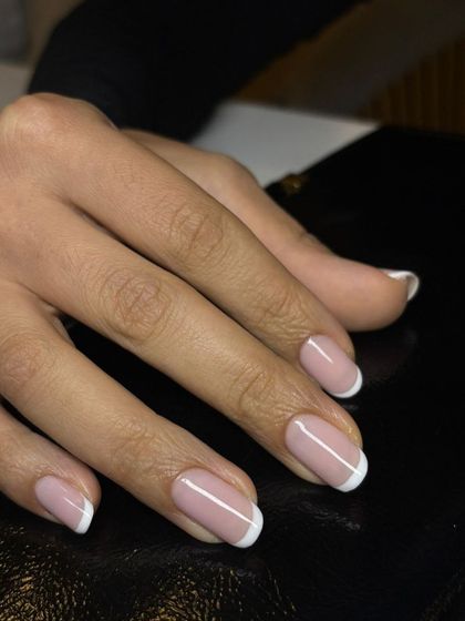 A simple and elegant French manicure on short, natural nails. This look is perfect for a clean, polished, and professional appearance.