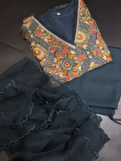 A stunning ready-made dress set in a deep teal color. The pure Chanderi kurti features a beautiful floral block print and is paired with a simple bottom and a delicate organza dupatta with scalloped edges.