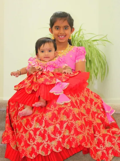 There's nothing sweeter than sibling love. I adore creating custom twinning outfits, like this layered red and pink Banarasi set, for sisters to share special occasions together.
