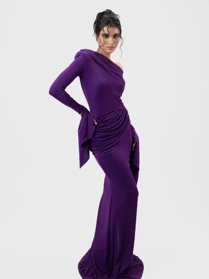 A full-length shot of a model in a purple gown, featuring a wet-look updo I created. The hairstyle is both elegant and edgy, designed to complement the draping of the dress.