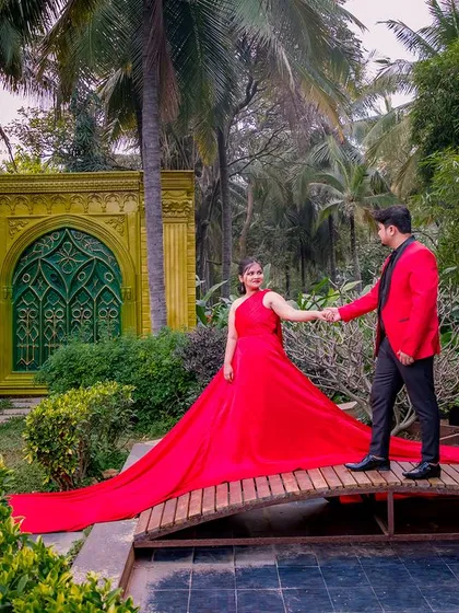 A couple with a flowing red gown on the wooden bridge, a classic and dramatic shot.