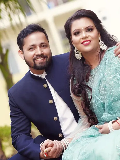A sweet and classic portrait of the couple. The groom has his arm around his fiancée, and they both share a warm smile for the camera.