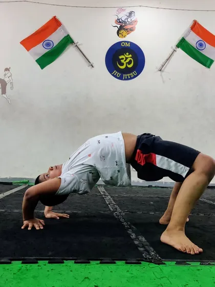 Another student practicing the wheel pose. This posture requires strength in the arms, legs, and back, making it a great full-body exercise.
