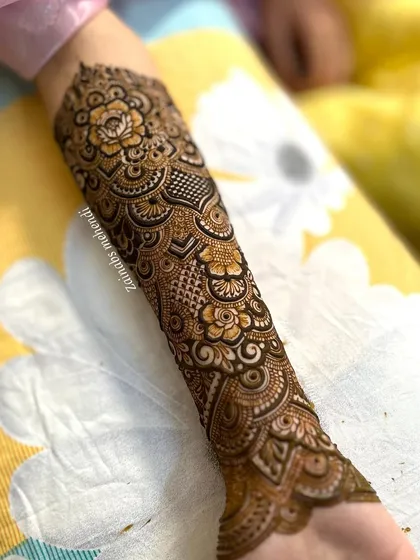 A full forearm design for bride Momina, featuring a dense pattern of roses and other floral elements.