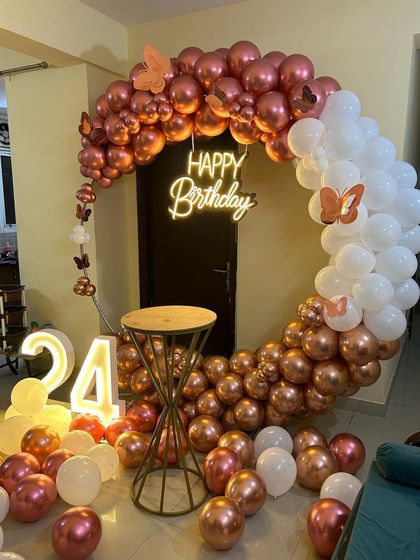 This is a duplicate of ID 10, 57, 76, 81, 120. An elegant and modern ring backdrop is perfect for home celebrations. The setup features a circular frame with a rose gold and white chrome balloon arrangement, a 'Happy Birthday' neon sign, and a light-up marquee number '24'.