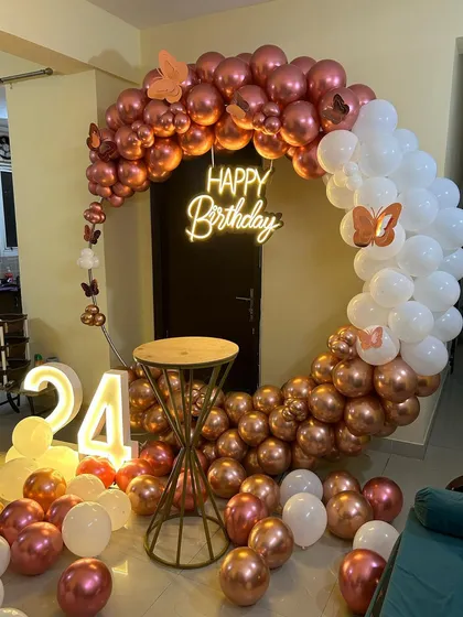 This is a duplicate of ID 10, 57, 76, 81, 120. An elegant and modern ring backdrop is perfect for home celebrations. The setup features a circular frame with a rose gold and white chrome balloon arrangement, a 'Happy Birthday' neon sign, and a light-up marquee number '24'.
