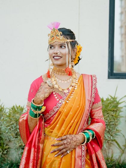 A full length shot of the bride in her yellow and pink Nauvari saree, showcasing the perfect drape.