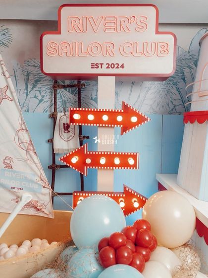 Light-up marquee arrows point the way to the celebration, adding a touch of vintage carnival flair to the nautical theme.