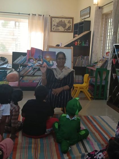 A storyteller reads to an engaged group, including one child who has come dressed as his favorite superhero. We welcome all forms of imagination.