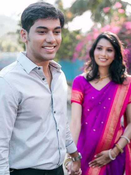 A natural, unposed shot of the groom walking and smiling, with his bride looking on lovingly in the background. This tells a story of partnership and affection.