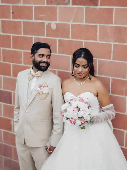 A candid, shared glance between the couple against a simple brick backdrop. My goal is to capture these unposed, real interactions that tell your story.