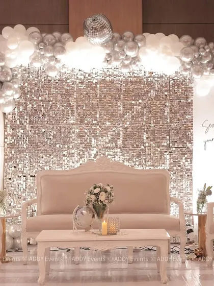 We designed this glamorous and modern stage for a 75th birthday celebration. The setup features a silver shimmer wall, a balloon arch in a monochrome palette, and elegant velvet seating, proving that milestone events can be both sophisticated and fun.