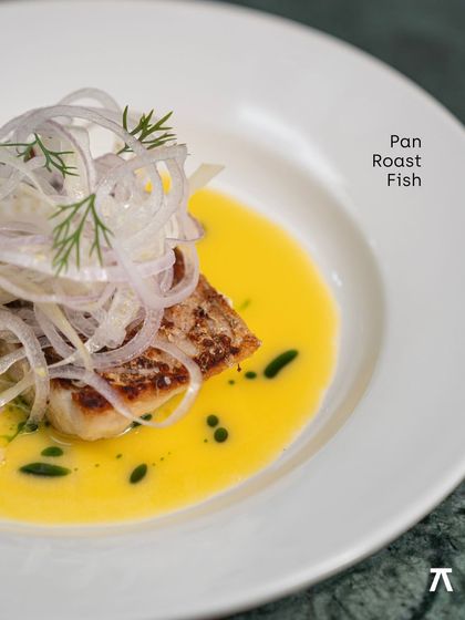 A close-up of the Pan Roast Fish, showcasing the crispy skin and delicate fennel salad from the Praça Prazeres pop-up.