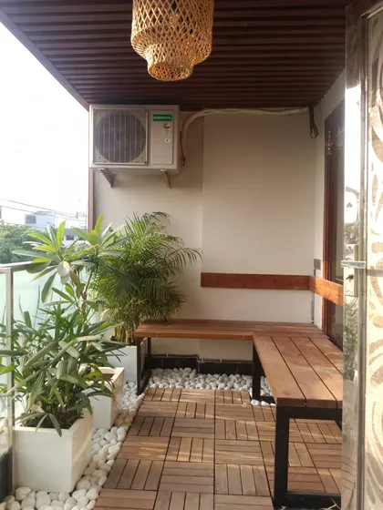 Even small balconies have great potential. We installed durable wooden deck tiles and a custom L-shaped bench to create a functional and cozy seating nook, proving no space is too small for a big upgrade.