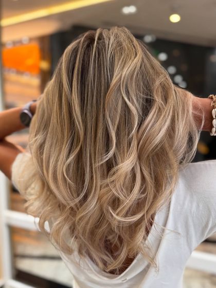 The back view of the platinum blond blend, showcasing the even lift and beautiful, wavy styling.