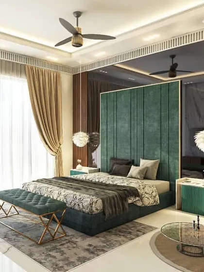 This bedroom design uses a bold color palette, with a deep green velvet headboard and a mustard yellow sofa. The back wall features a combination of a large mirror and wood paneling, which adds depth and texture to the space.
