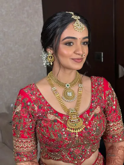 A soft glam bridal look that whispers elegance. This bride in red has dewy skin, featherlight eyes, and a subtle blush, perfect for the bride who wants to glow, not shout.
