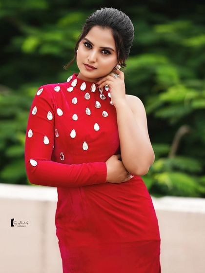 A close-up portrait of Thanvi, showing off the details of her crystal-adorned dress and her bold, confident makeup.