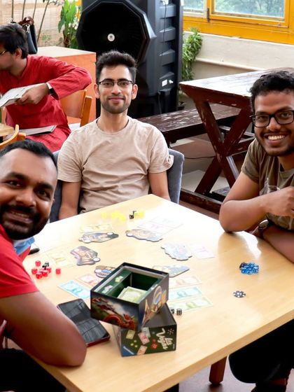 This trio is enjoying a strategic board game on a weekend afternoon. My cafe provides the perfect backdrop for friends to connect over shared hobbies.