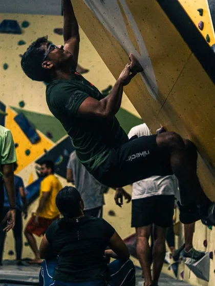 It's all about focus and determination. This close-up shot captures the intensity and physical effort required to hold on and push through a difficult bouldering problem, showcasing true grit and climbing form.
