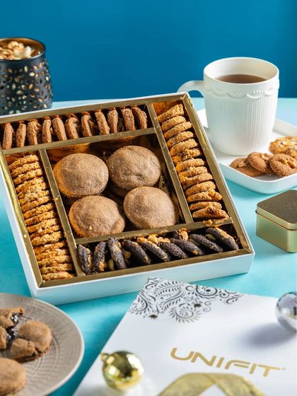 A premium white gift box of Unifit cookies, styled with a cup of tea for a sophisticated look.