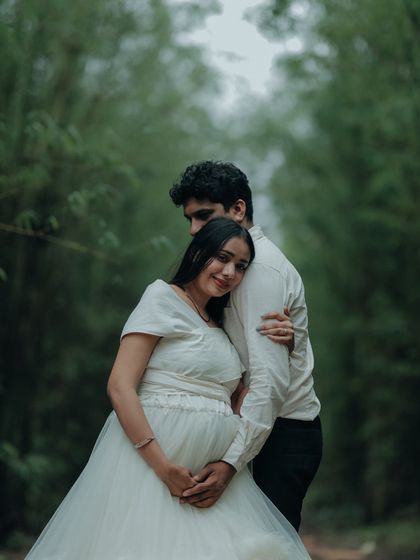 A loving embrace in a beautiful bamboo forest. The white gown provides a lovely contrast to the green background, creating a fresh and natural feel.