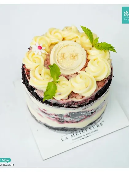 A beautifully composed shot of our Red Velvet pastry, garnished with fresh mint leaves and our signature 'LM' chocolate coin.