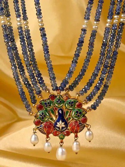 A detailed shot of the reverse enamel side of the pendant against a golden background, highlighting the rich colours and craftsmanship.