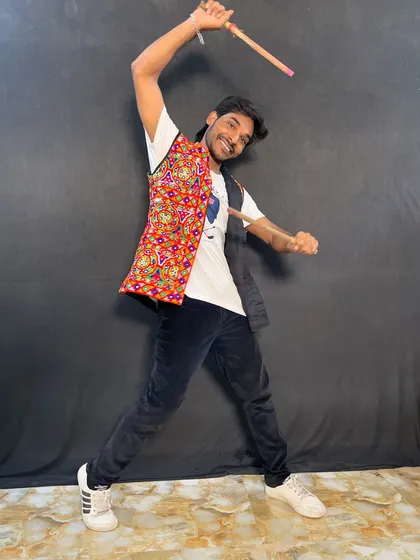 An energetic pose with dandiya sticks, ready for a lively performance.