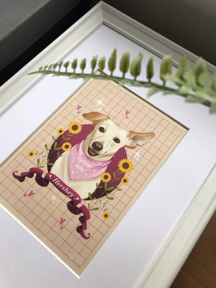 The framed portrait of Hershey, seen from an angle with a plant in the foreground. This shows how the final piece can integrate beautifully into a home environment.