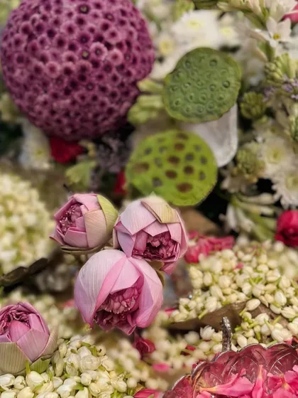 Traditional flowers, candles, and lots of fragrant mogra (jasmine). This close-up shows the beauty of Indian floral traditions, with lotus buds and pods nestled in a bed of fresh jasmine.