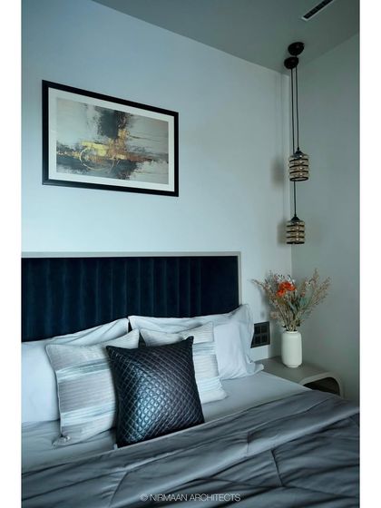 A close-up of the bedside details in the master bedroom at Tulsi Heights. The hanging pendant lights save space on the nightstand and add a touch of modern elegance.