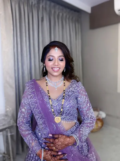 A serene shot of the bride, her eyes closed to show off the beautiful silver and purple eyeshadow work.