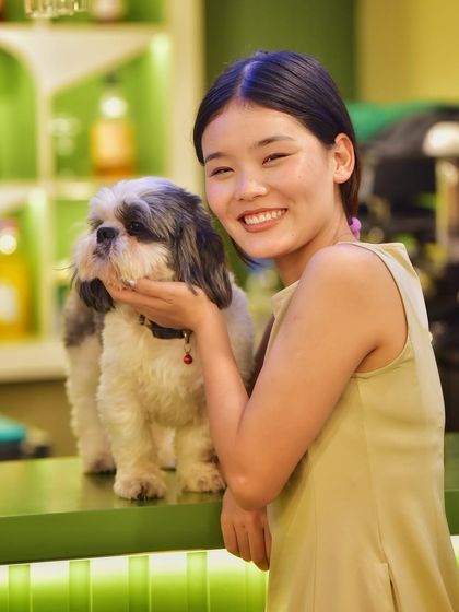 A sweet moment between a woman and her furry friend. The gentle way she holds the dog and her bright smile show the special bond they share.