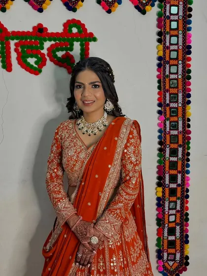 A full view of her stunning engagement look against a traditional backdrop. The makeup is kept fresh to balance the richly detailed outfit.