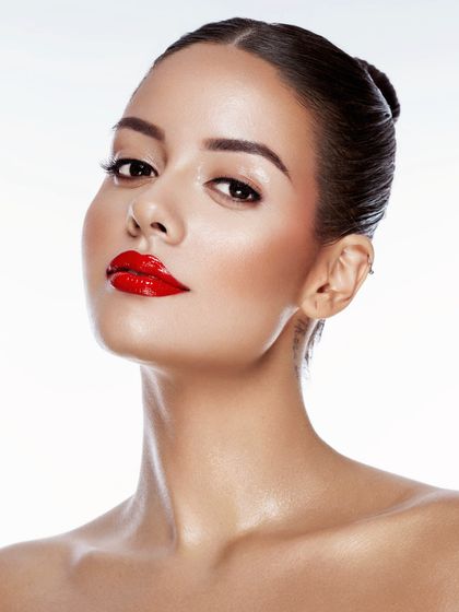 Dewy dreams and glossy reds. This shot captures the light beautifully on the skin, a result of strategic highlighting and skin prep.