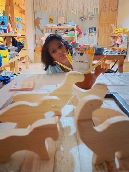 The look of pure creative potential. A young artist contemplates her next masterpiece with our wooden animal cutouts, ready to be brought to life with color.