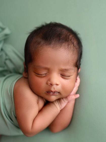 A close-up on his sweet face. The green backdrop is so calming and complements his skin tone beautifully.