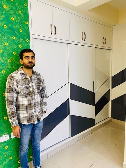 Standing next to a completed sliding wardrobe with a striking geometric pattern, a great way to make a statement in a modern bedroom.
