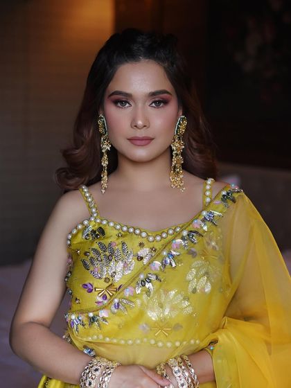 Another angle of this beautiful Haldi glam. The makeup is designed to complement the intricate embroidery and heavy jewelry.