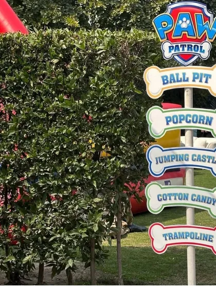Themed signage helps guide guests to all the fun activities. This Paw Patrol signpost points the way to the ball pit, popcorn, jumping castle, cotton candy, and trampoline, building excitement for the little pups.