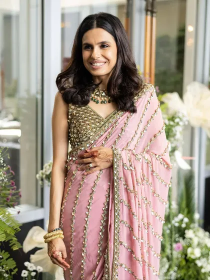 A full-length view of this elegant look for the sister of the groom. The makeup is soft and natural, perfectly complementing her beautiful pink sari and ensuring she looks graceful and stylish.
