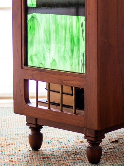 The Aamira storage unit is a piece with details galore. It can function as a bookcase, crockery unit, or bar, and features finger grooves, stained glass, and brass inserts, making it a statement piece for any living or dining area.